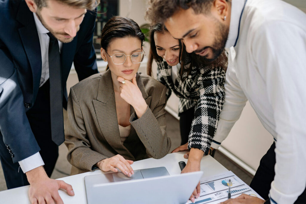 men and women looking over a computer